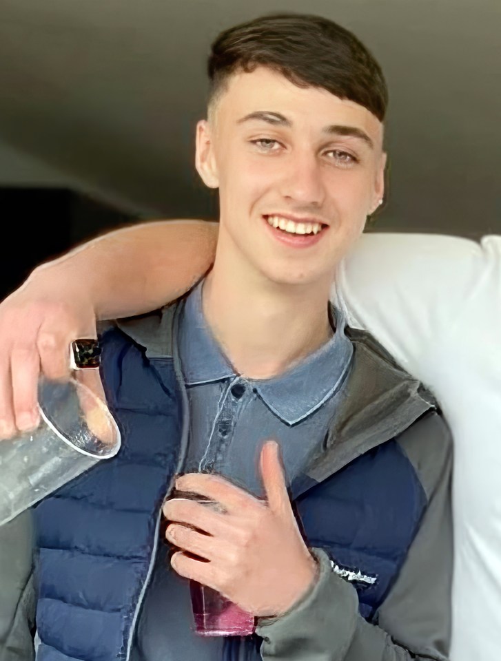 a young man wearing a berghaus vest is holding a glass of water