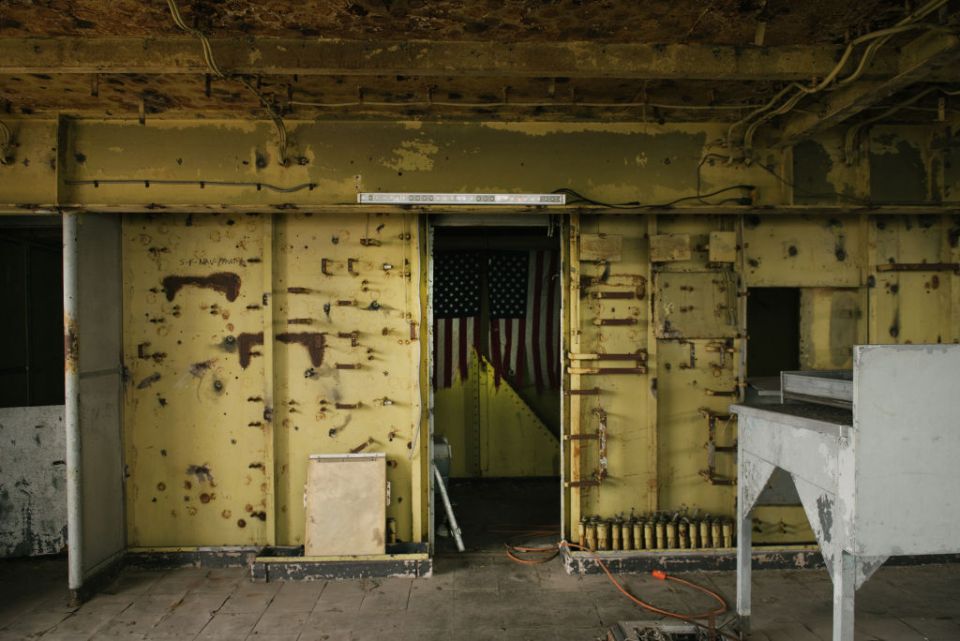 an american flag is hanging on a yellow wall