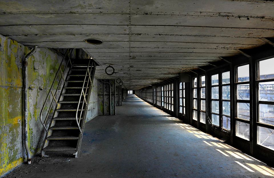 a long hallway with stairs and lots of windows