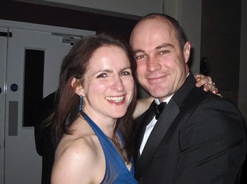 a man in a tuxedo and a woman in a blue dress pose for a picture