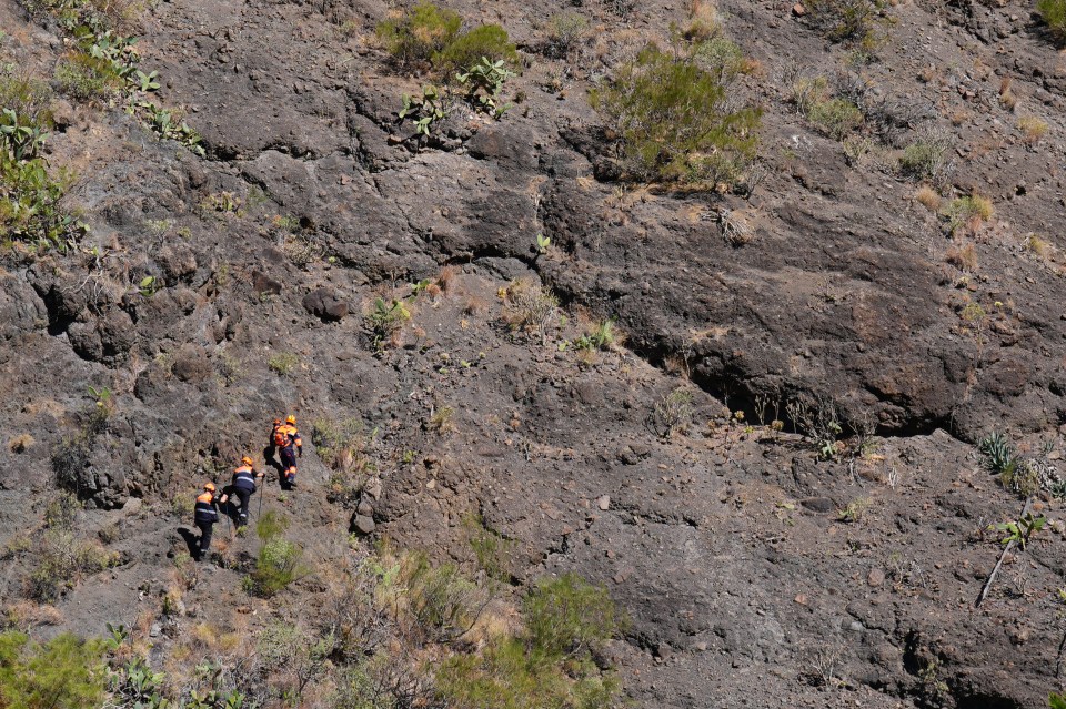 a group of people are hiking up a rocky hillside