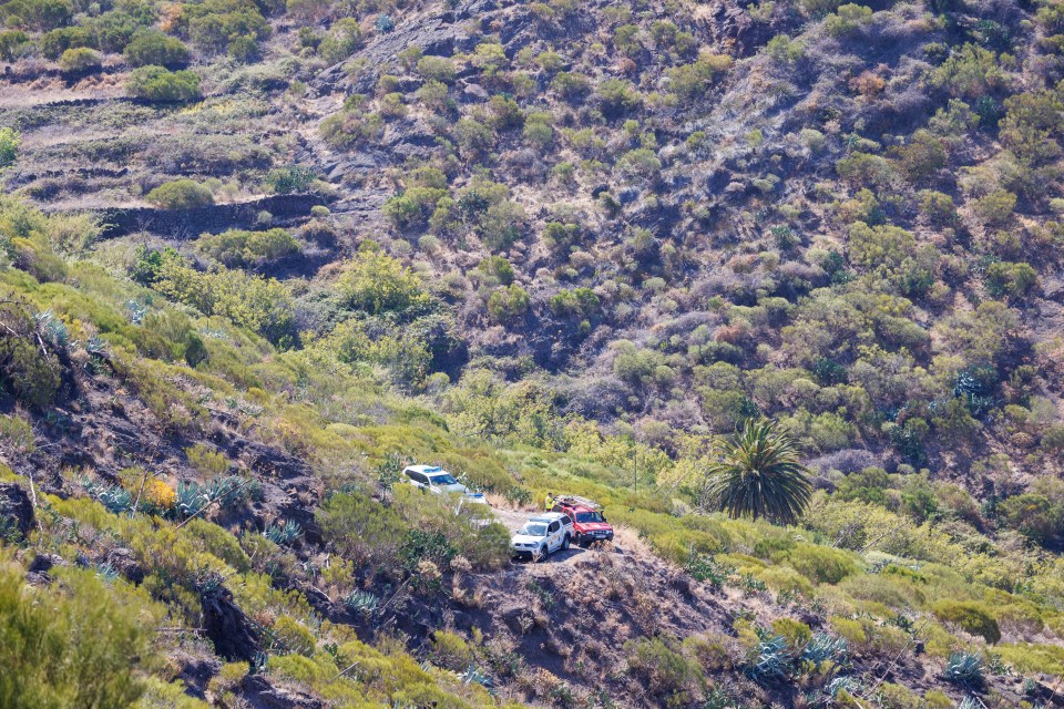 a few cars are parked on the side of a hill