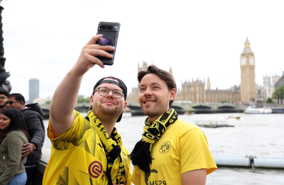 Two Dortmund fans pose for a selfie in front of the Houses of Parliament