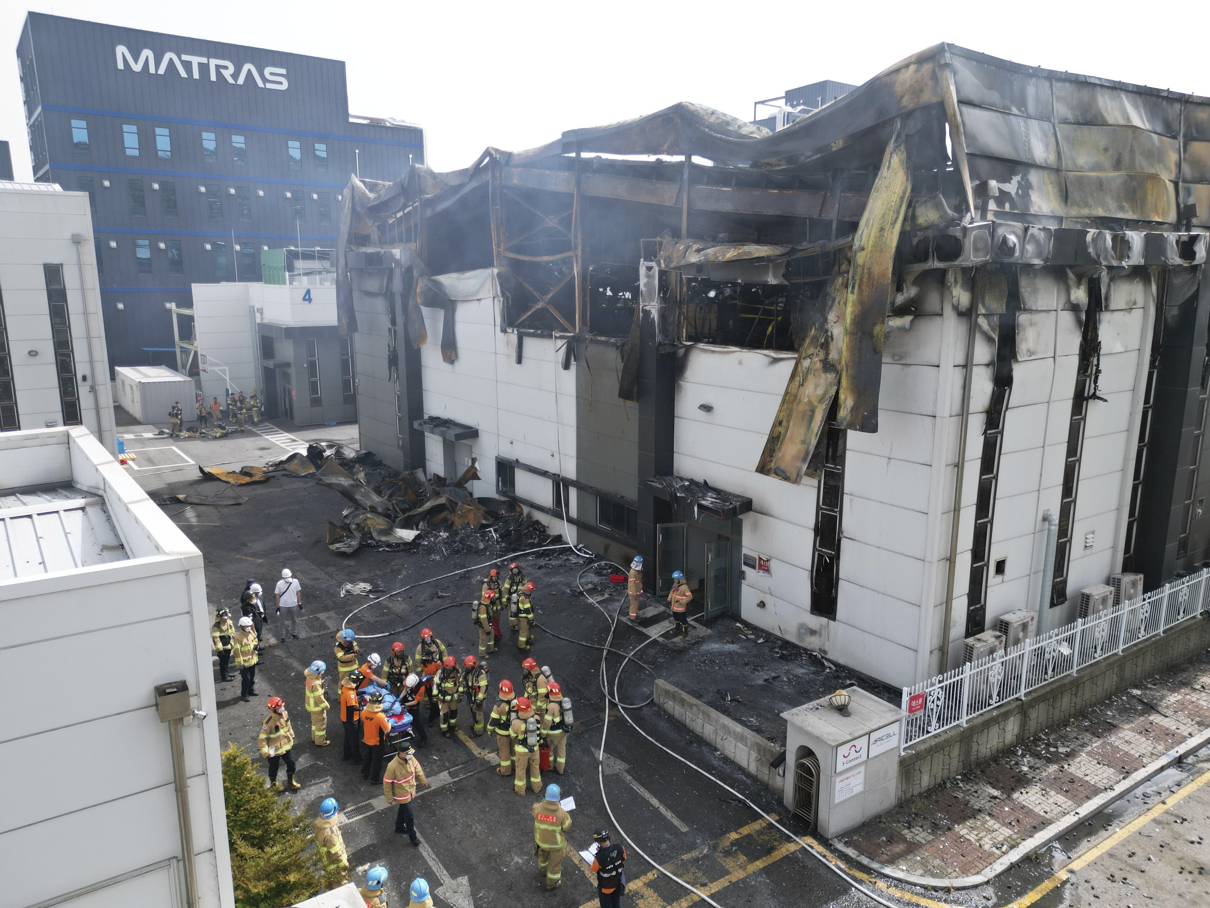 Fire officials gathered outside the collapsing factory after the devastating fire