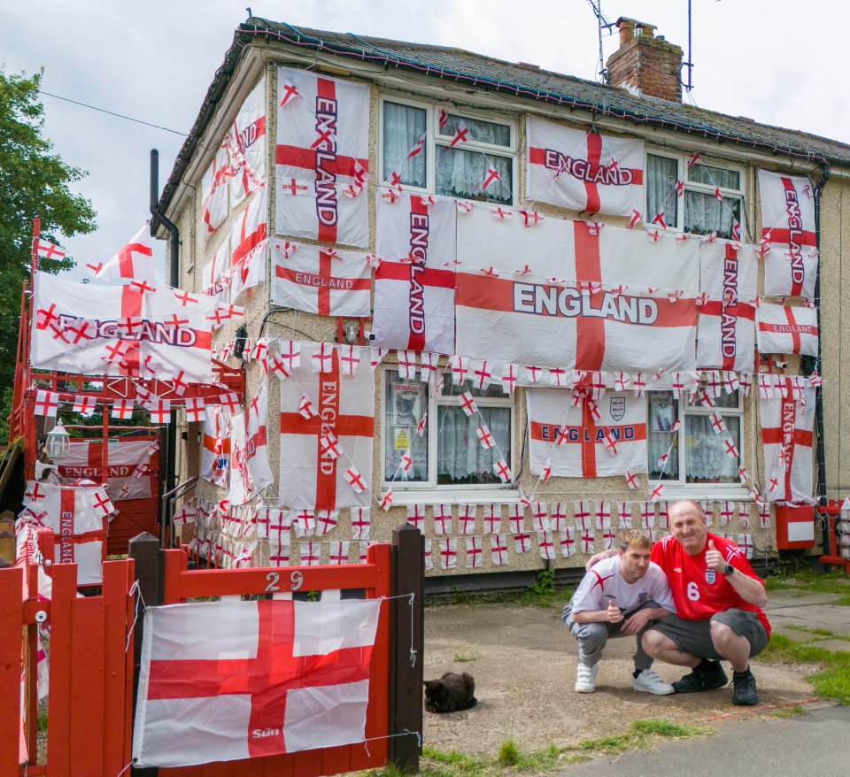 Football crazy Paul Bibby, 58 with son Aaron, 37 outside his England flag covered house in Essex