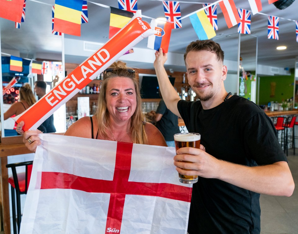 Coworkers Carla Ingham and Lukas Betin posing with their flags