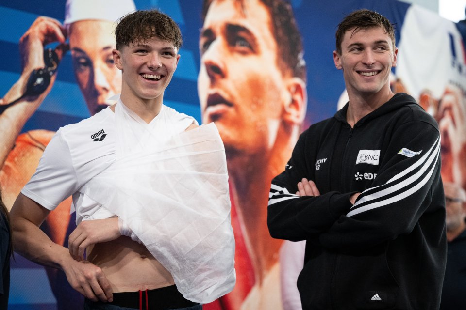 Fente-Damers smiles alongside Maxime Grousset while wearing his sling