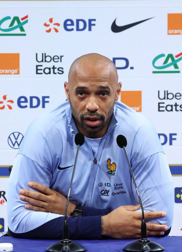 a man sitting in front of microphones with uber eats edf and nike logos behind him