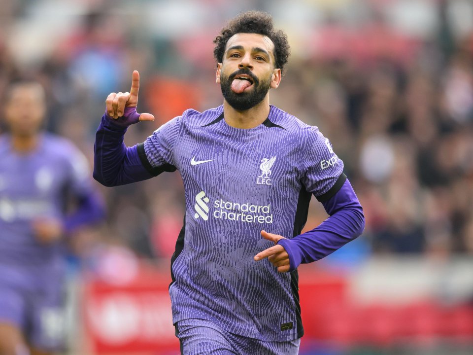 a soccer player wearing a purple jersey that says standard chartered on it