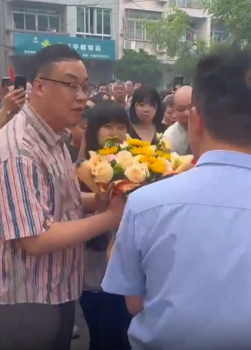 The family handed Zhang two bouquets of flowers