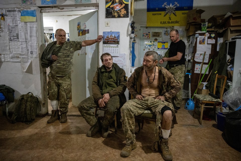 Injured soldiers wait at a medical stabilisation point near the frontline