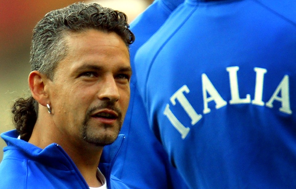 a man with a ponytail is wearing a blue italia shirt