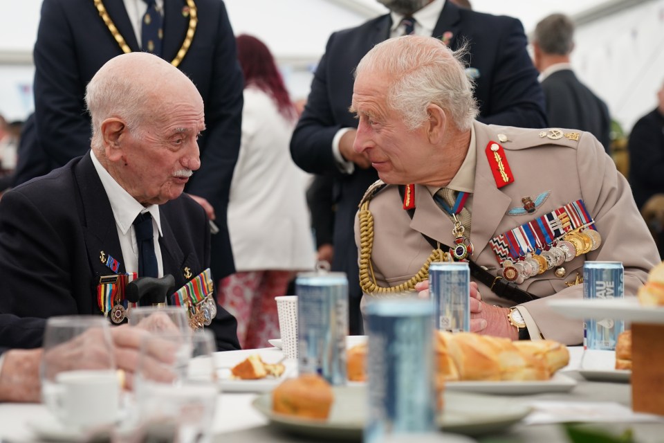 Charles speaks with D-Day veteran Arnie Salter, 98, from Warwickshire, during a lunch