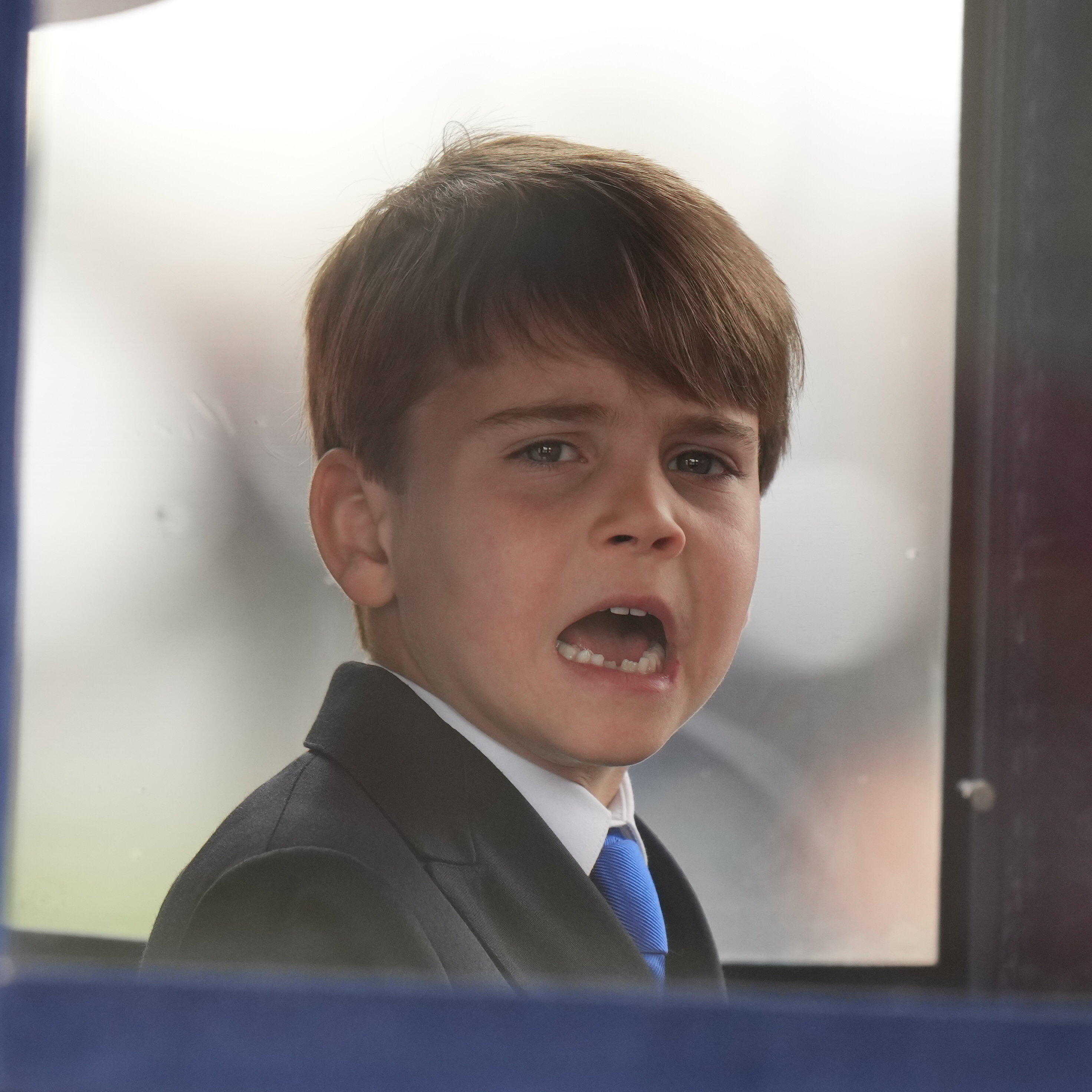 A cute Prince Louis was snapped pulling faces from inside the carriage