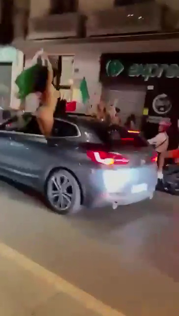 A topless Italian fan waved flags from her car