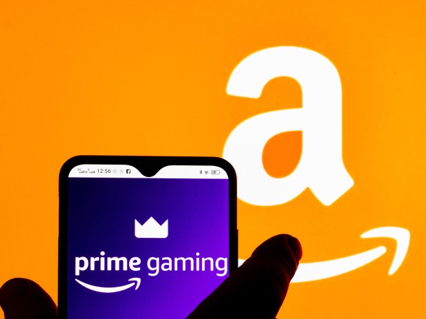 a person holding a phone that says prime gaming on the screen