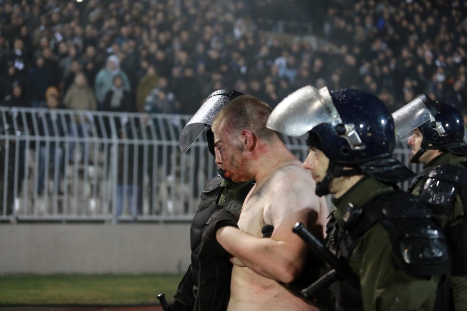 A policeman arrests a supporter after clashes between Red Star Belgrade’s and Partizan Belgrade’s hooligans