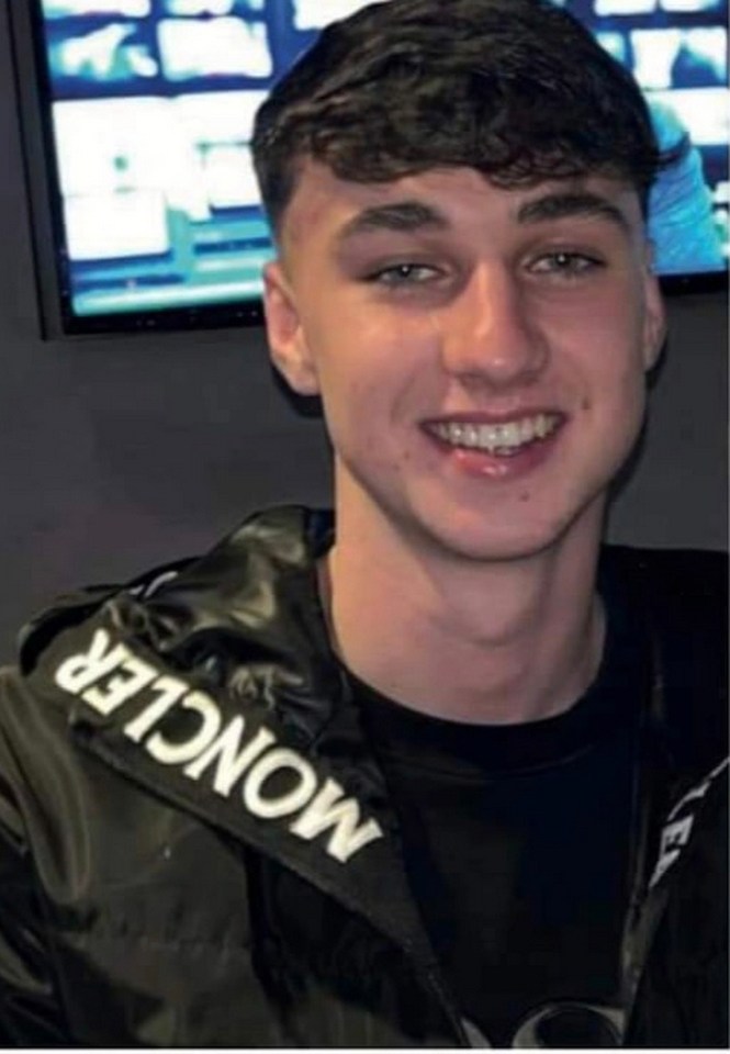 a young man wearing a black moncler jacket is smiling for the camera .