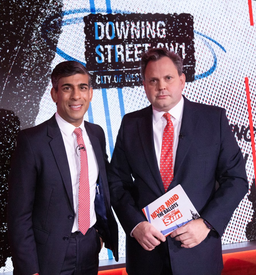 two men standing in front of a downing street sign