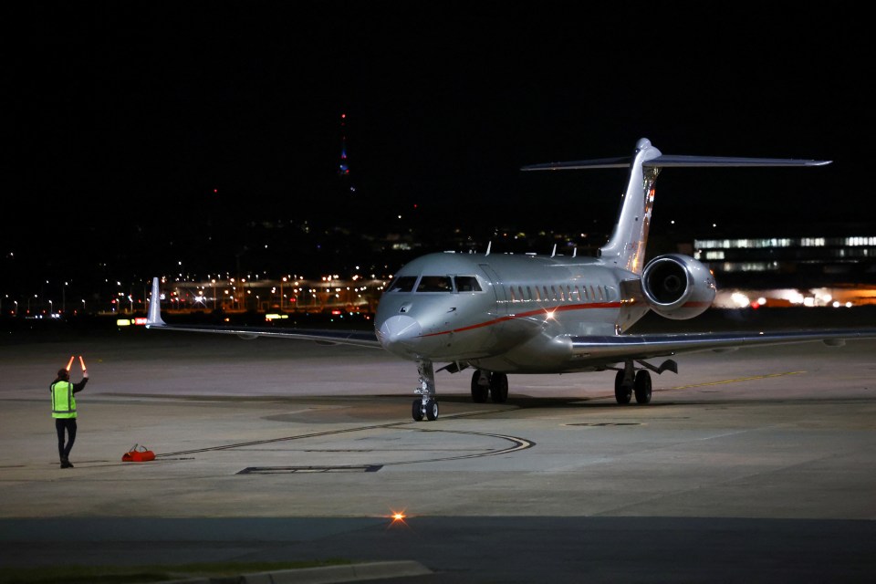 an airplane is parked on a runway at night