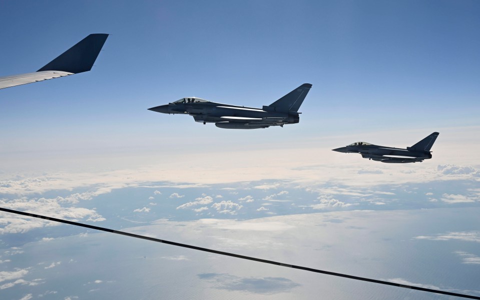 two fighter jets are flying side by side in the sky