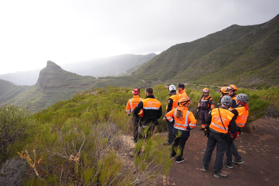 a group of people standing on top of a mountain wearing safety vests with the word rescue on them