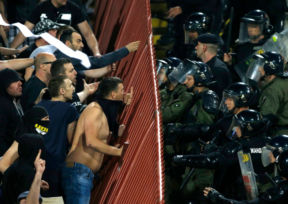 Serbian riot police officers push back hooligans during a match in 2018