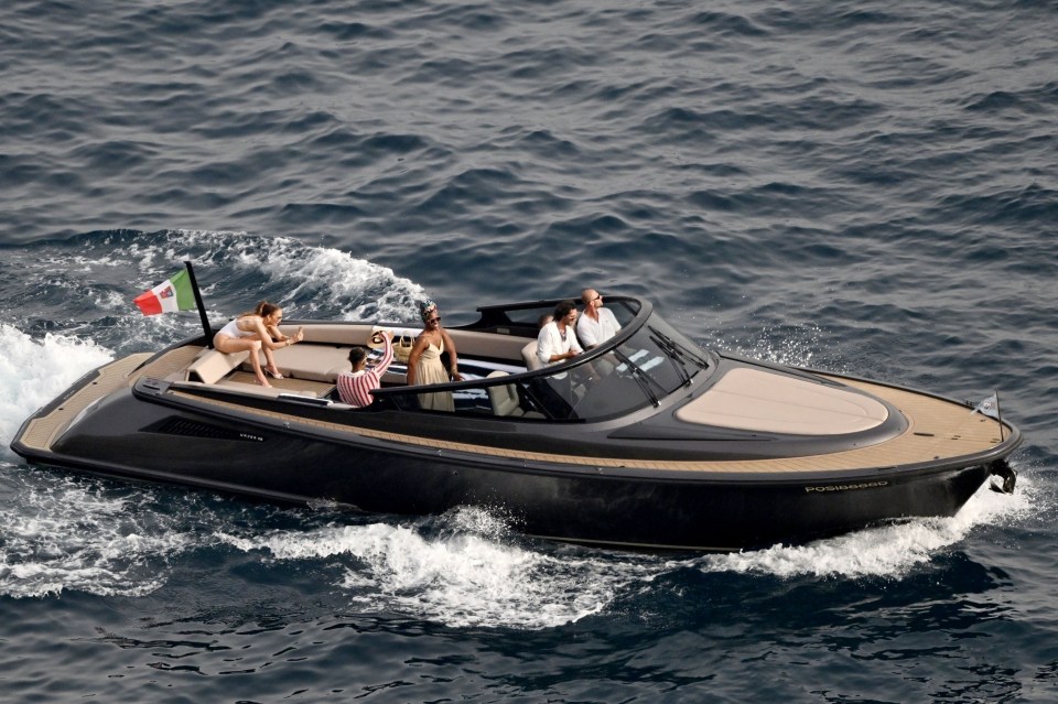 J-Lo sitting alone and snapping selfies at the rear of the speedboat