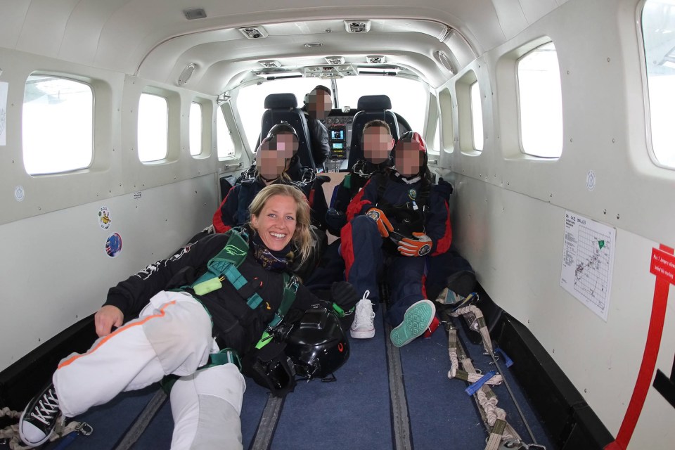 a group of people are sitting in a plane with a sign on the wall that says emergency exit