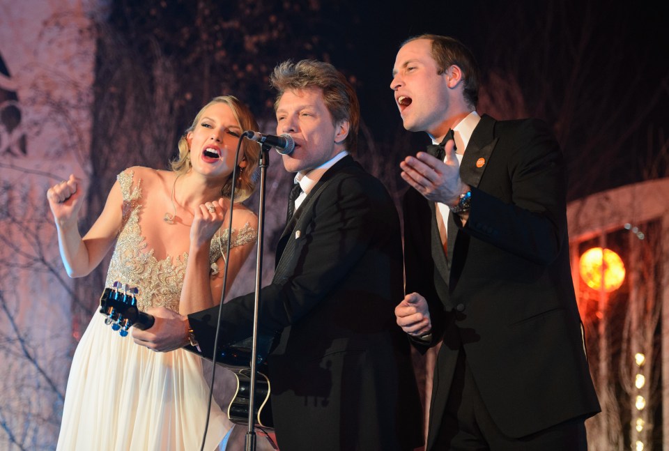 two men and a woman singing into microphones on a stage