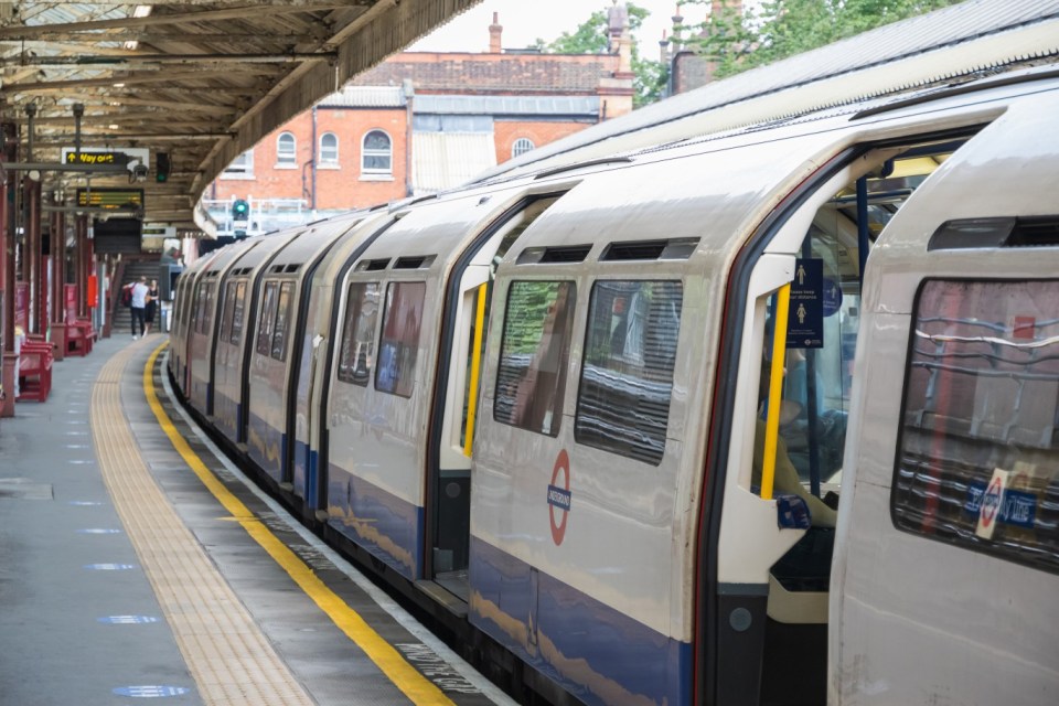 London, UK - 21 July, 2021 - A London Underground tube train waiting at Barons Court station, empty platform