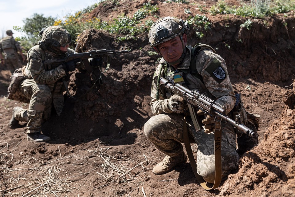 Ukrainian troops are seen in a trench with military equipment as war rages in Donetsk Oblast