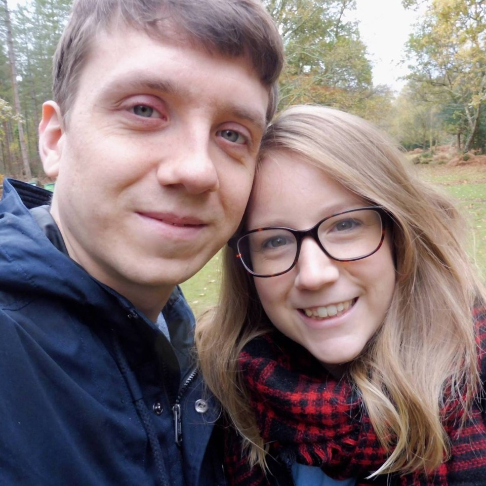 a man and a woman are posing for a picture and the woman is wearing glasses