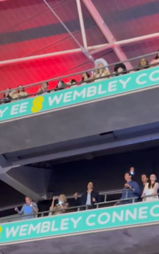 a group of people are sitting in the stands of a stadium .