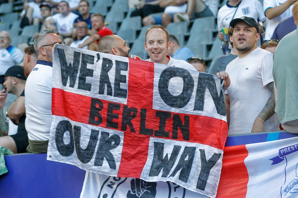 a man holding a sign that says we 're on berlin our way