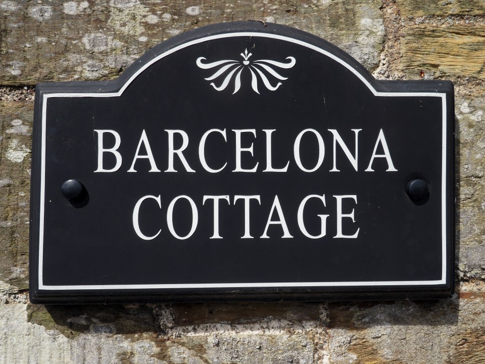 a black sign that says barcelona cottage on it