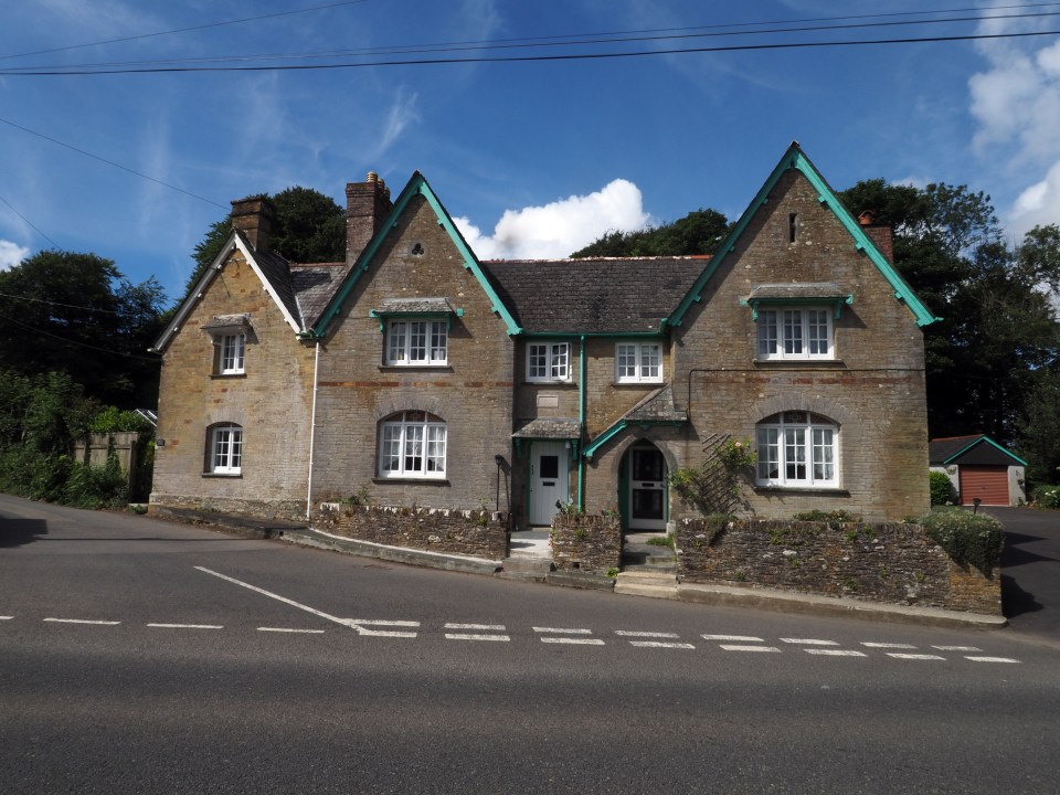 a brick house with green trim and white windows