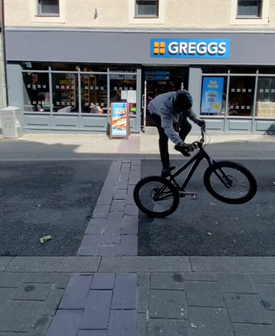 Matty, 24, doing tricks on his bike outside the popular chain