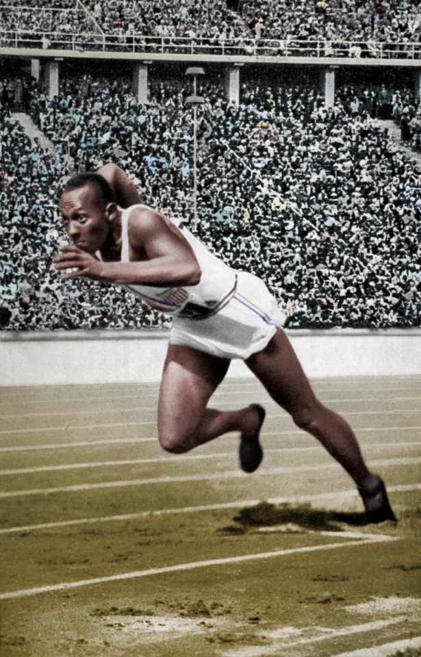 a man is running on a track in front of a crowd