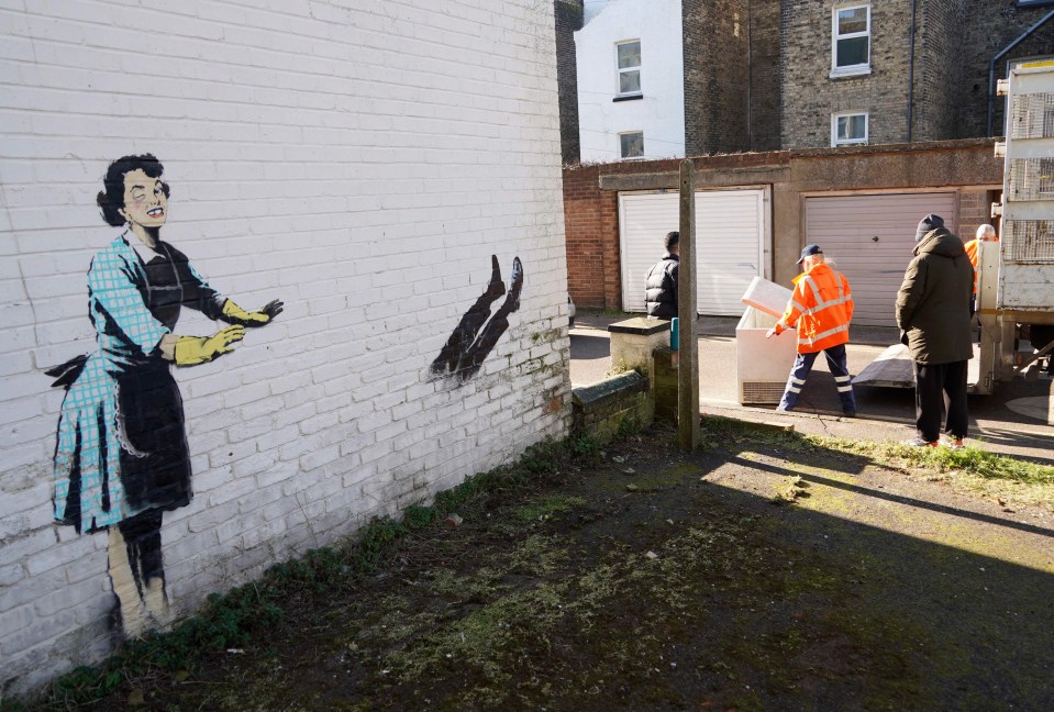 a painting of a woman wearing gloves on a brick wall