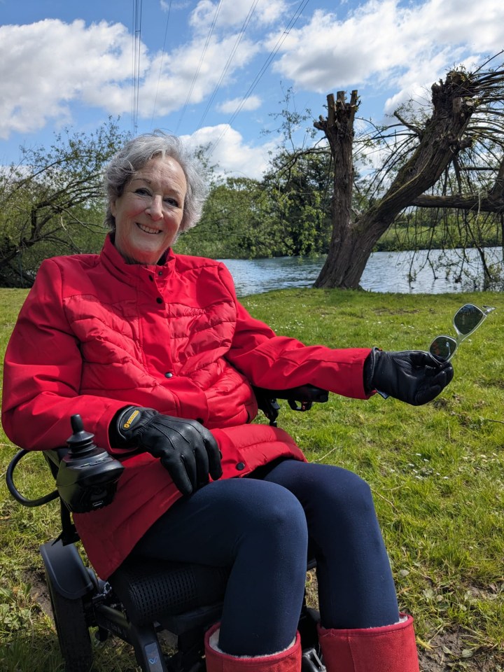 a woman in a red jacket is sitting in a wheelchair