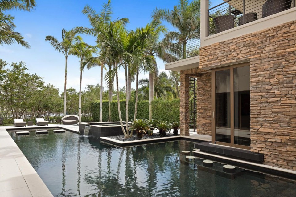 a large swimming pool is surrounded by palm trees