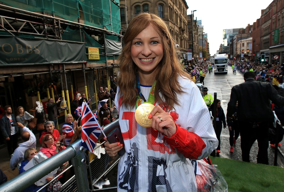 a woman holding a gold medal that says u.k. on it