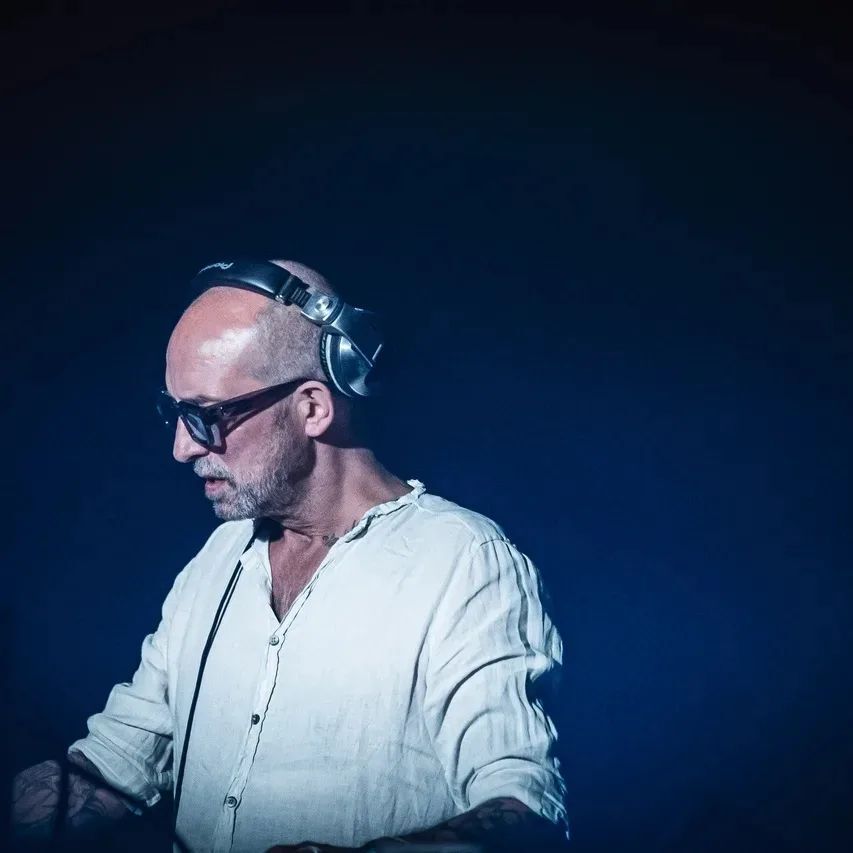 a bald man wearing headphones and sunglasses is playing music