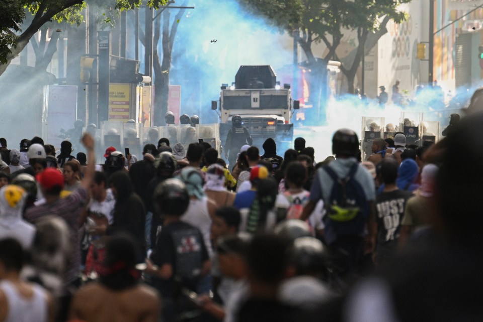 Demonstrators clash with riot police in Caracas