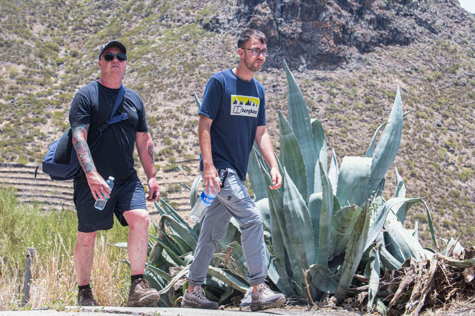 a man wearing a berghaus shirt walks with another man