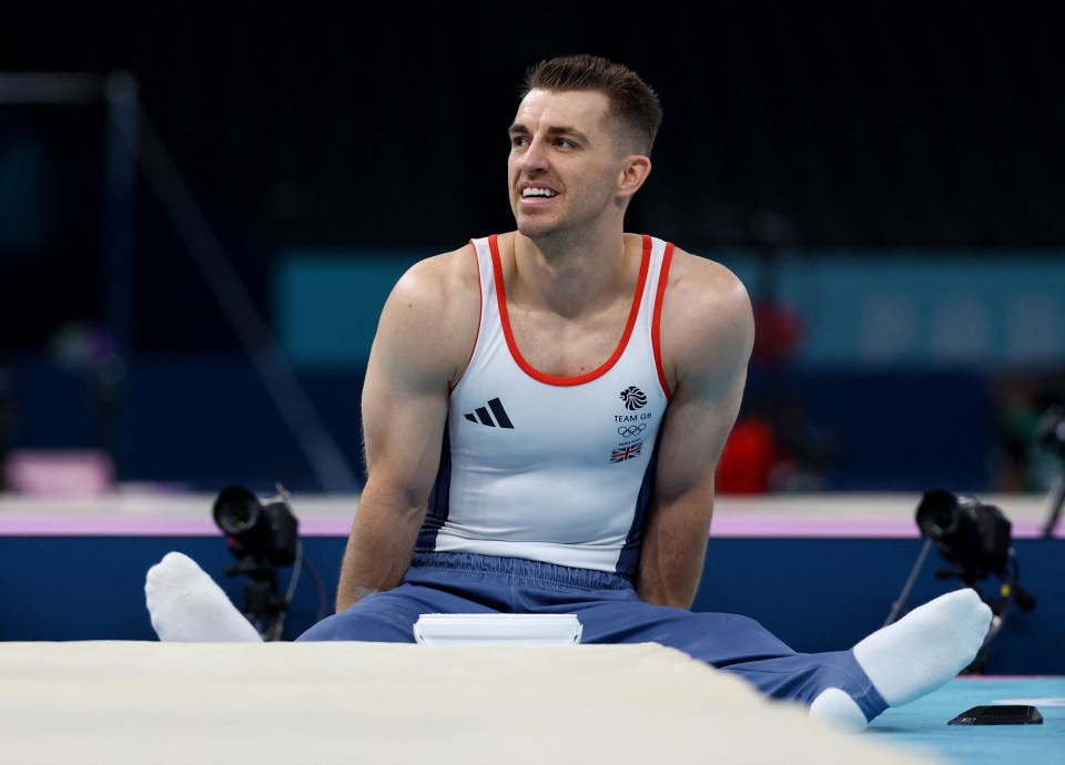 a man in a team gb olympics uniform sits on the floor