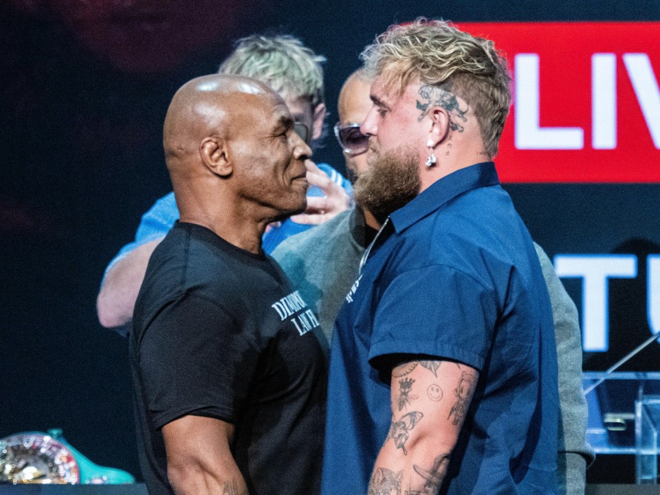 two men are looking at each other in front of a sign that says live