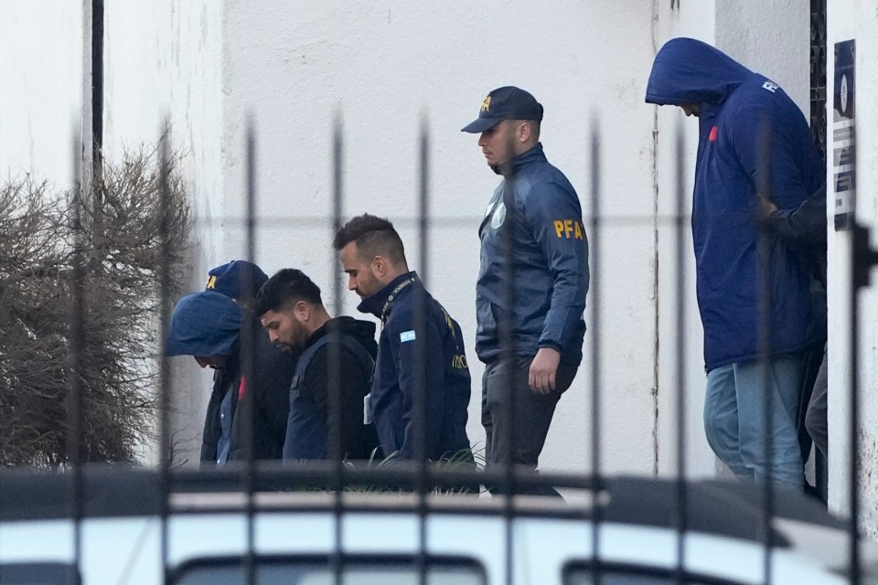 Both men had their hoods up as they left Interpol's Buenos Aires headquarters