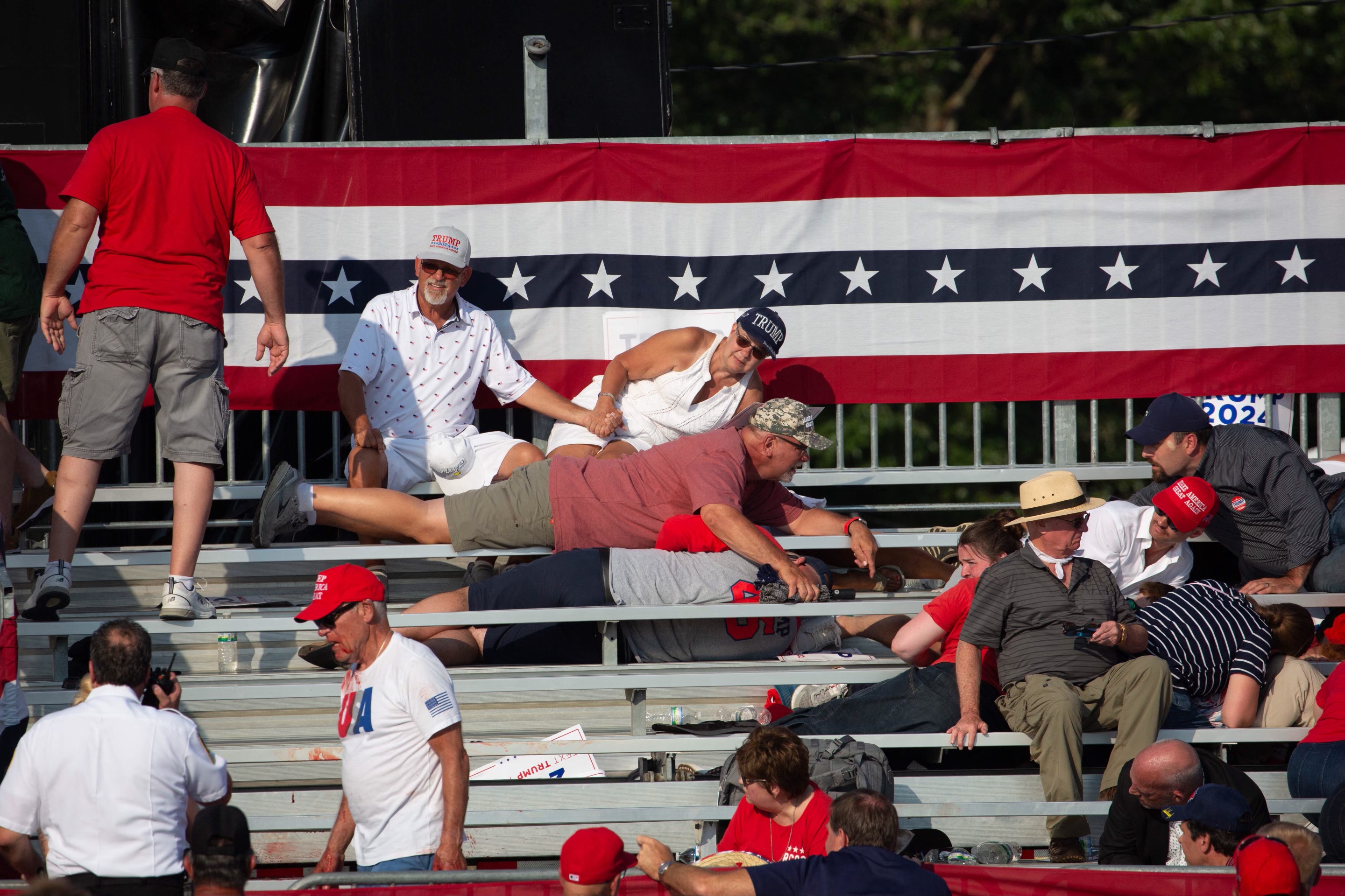 Supporters at the rally dive for cover on the benches